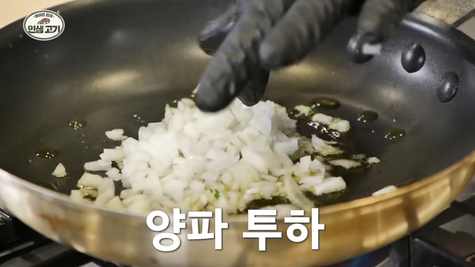 팬에 양파를 볶는 장면
