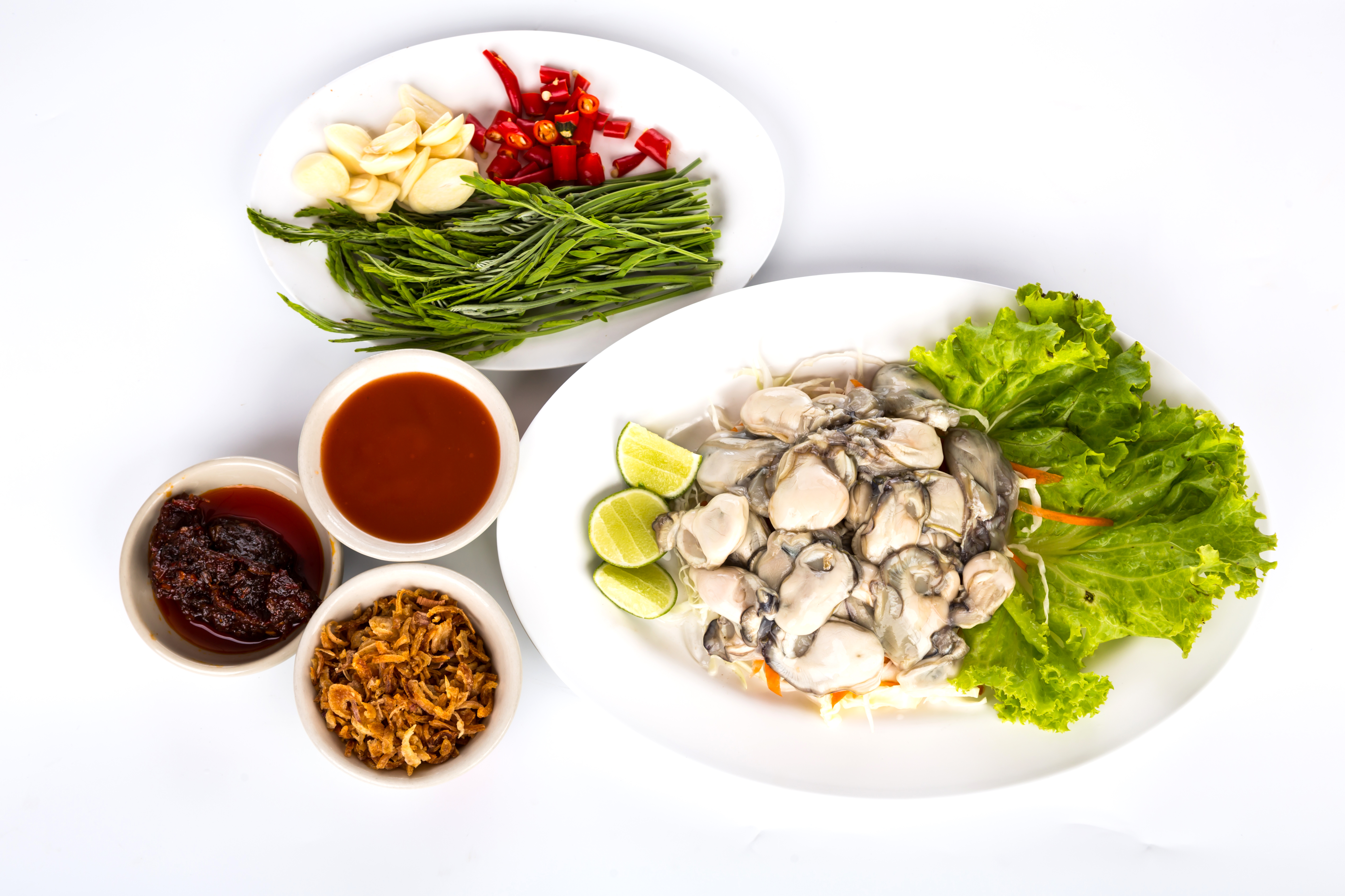 바다에서 채취를 한 굴을 까서 알맹이만 타원형의 플라스틱 그릇에 상추를 깔고 그 위에 레몬과 함께 놓아두고 그 위에는 타원형의 플라스틱 그릇에 고추와 마늘, 야채를 두었고, 그 밑에는 동그란 그릇에 고추장, 쌈장, 반찬을 각각 담아두고 찍은 사진