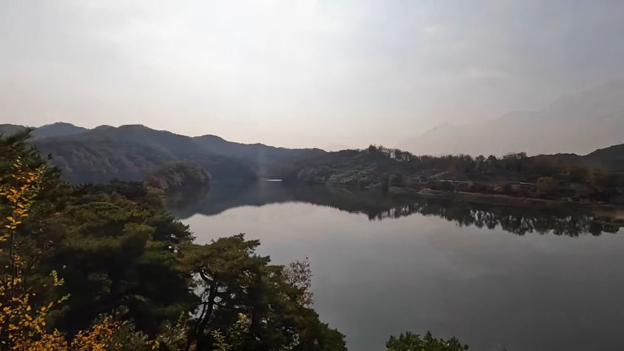 부소담악 호수 전경, 단풍 능선이 수면에 비친 역광 풍경.