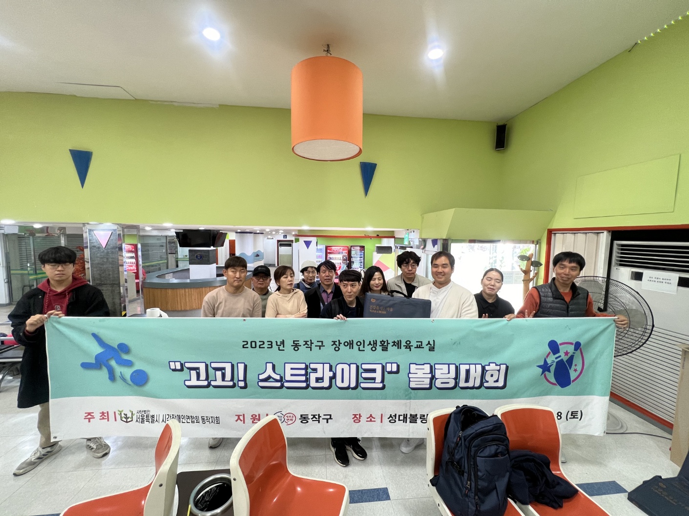 사진설명: 볼링대회 현수막과 함께 대회에 참여한 참여자들의 단체사진