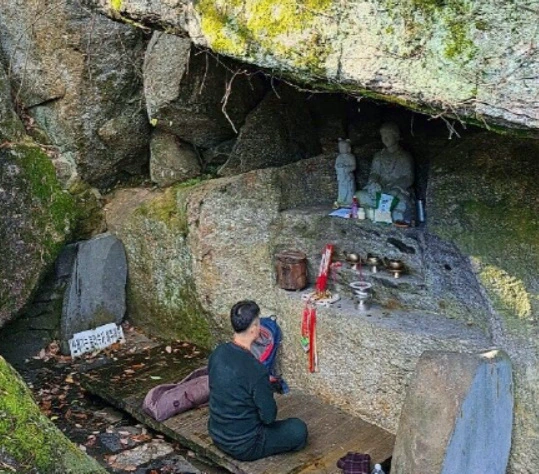 바위굴에 들어가서 기도하는 무속인