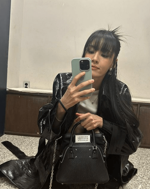 모니카가 거울 앞에서 셀피를 찍는 모습