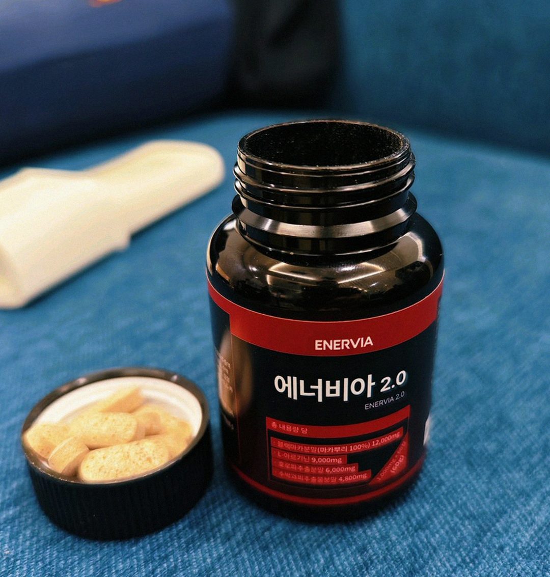 Korean Asian man in late 40s taking single supplement with water morning
