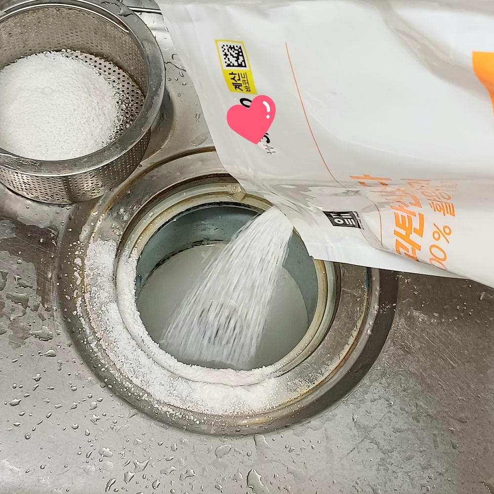 싱크대 배수구에 과탄산소다를 넣는 모습