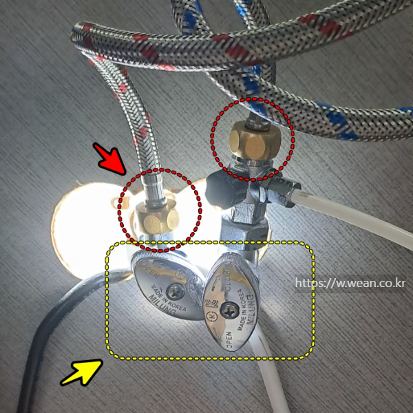 수전 호스를 밸브에 연결하고 있습니다.