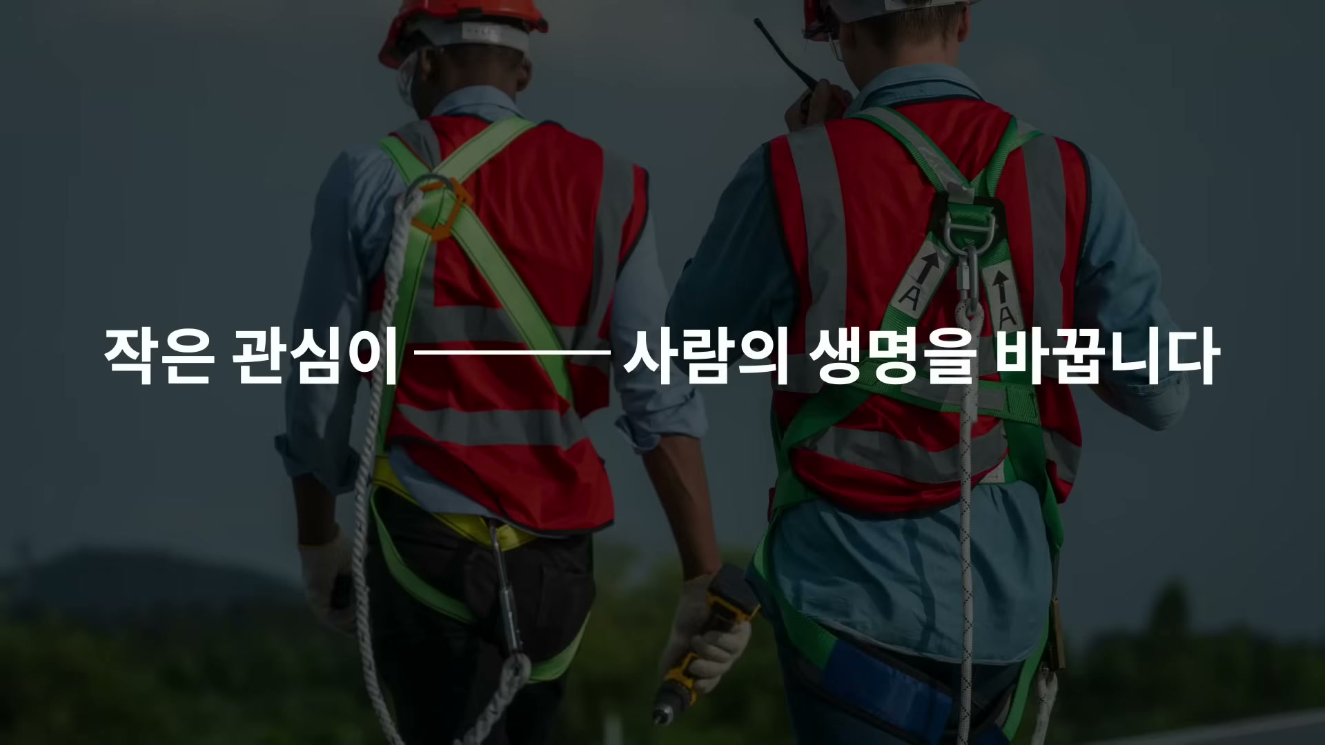안전 장비를 갖춘 두 노동자의 뒷모습 위에 작은 관심이 사람의 생명을 바꿉니다라는 자막이 떠 있다.