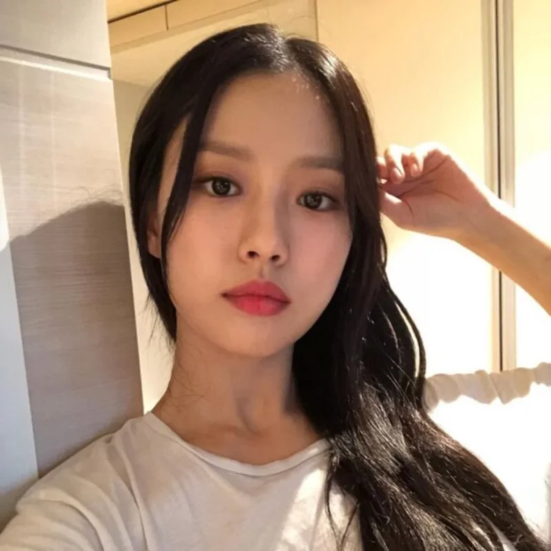 흰 반팔티를 입고 앉은 긴머리의 고민시