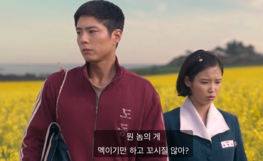 아이유와 박보검이 유채꽃밭에서 이야기 나누며 걷는 장면