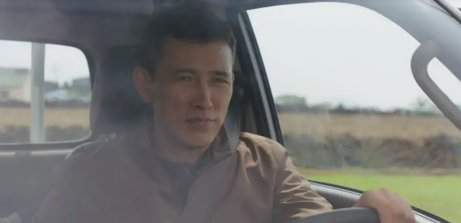 웰컴투삼달리- 머리가 히끗한 아저씨가 운전대를 잡고 운전하는 모습