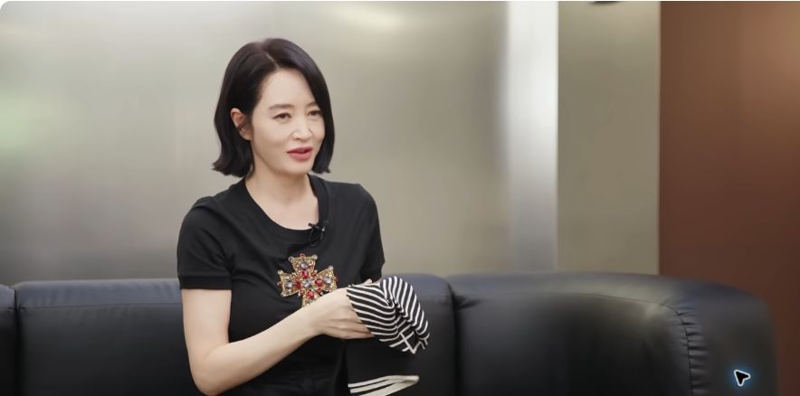 Kim Hye-soo holds a dark striped scarf while describing how she wears it as a head wrap