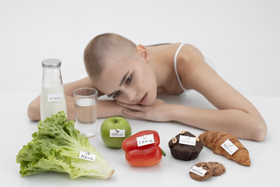 young-woman-with-eating-disorder-food-with-calories-numbers-900