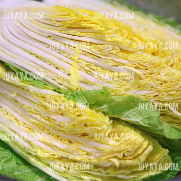 반으로 자른 배추의 단면&amp;#44; 얇고 겹겹이 쌓인 노란 속잎이 돋보이는 모습.
