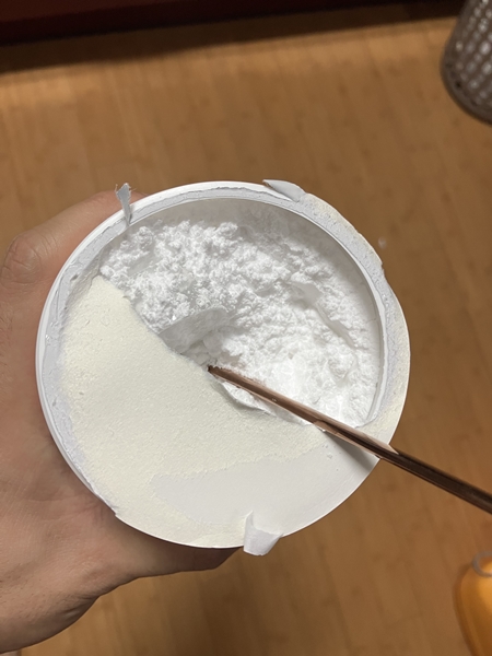 개봉된 뉴트리코스트 크레아틴 용기 내부 &ndash; 하얀 크레아틴 파우더와 젓가락으로 저어놓은 흔적