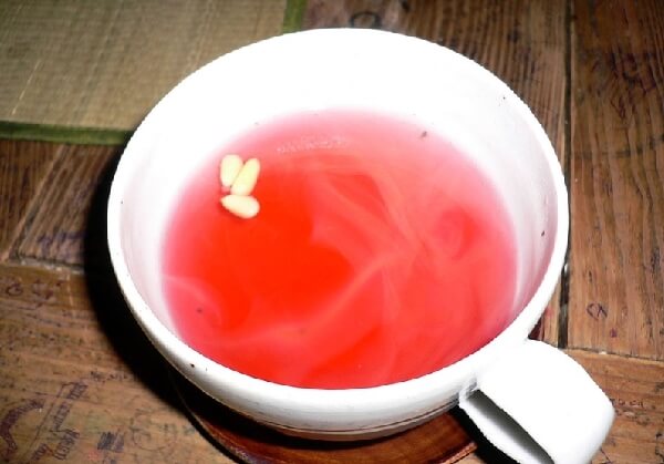 잣이 몇 알 떠있는 빨간 빛의 오미자차