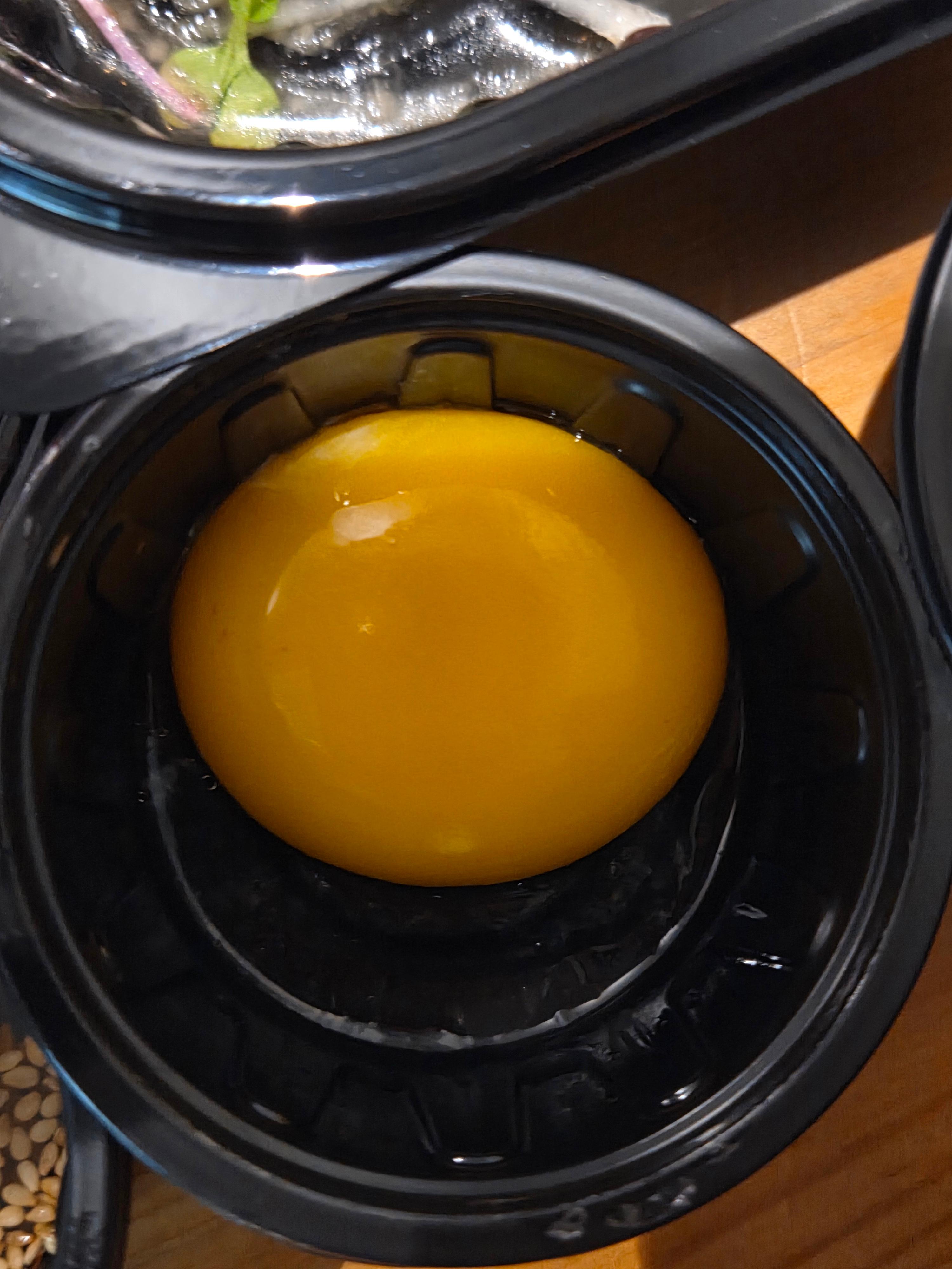 육회와 함께 곁들이는 노른자가 동그랗게 담긴 소스 용기