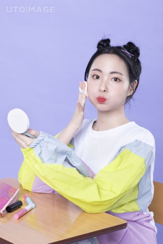 생기발랄한-여성이-화장대에-앉아-볼에-공기를-가득넣고-눈을-크게뜨면서-볼터치를-하고있는-모습