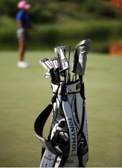 필드 위에 스탠드 골프백이 있고 거리측정을 하고 있는 이미지