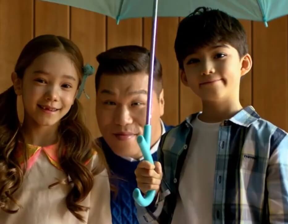 서장훈과-소년-소녀가-함께-우산을-쓰고-있습니다.