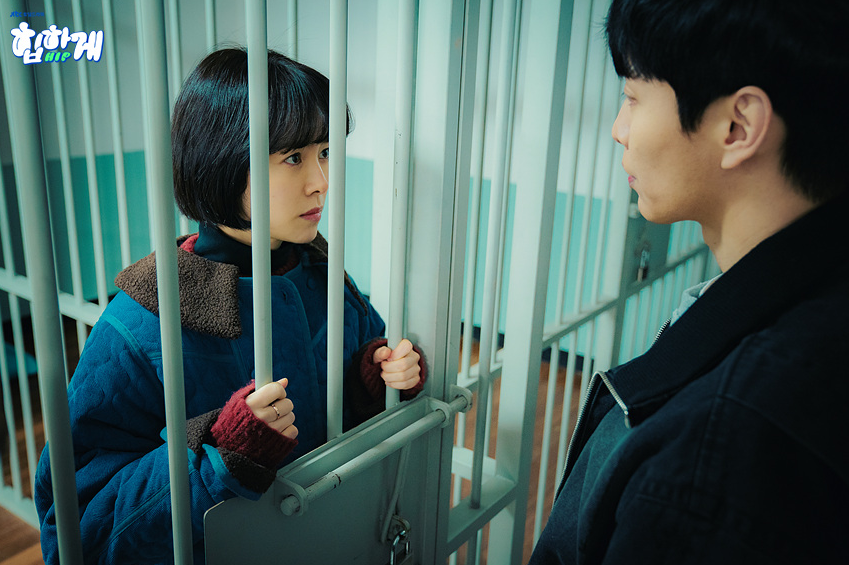 철창 너머로 서로를 바라보는 남녀 주인공, 감정이 고조된 채 마주 선 드라마 '힙하게'의 긴장감 넘치는 장면