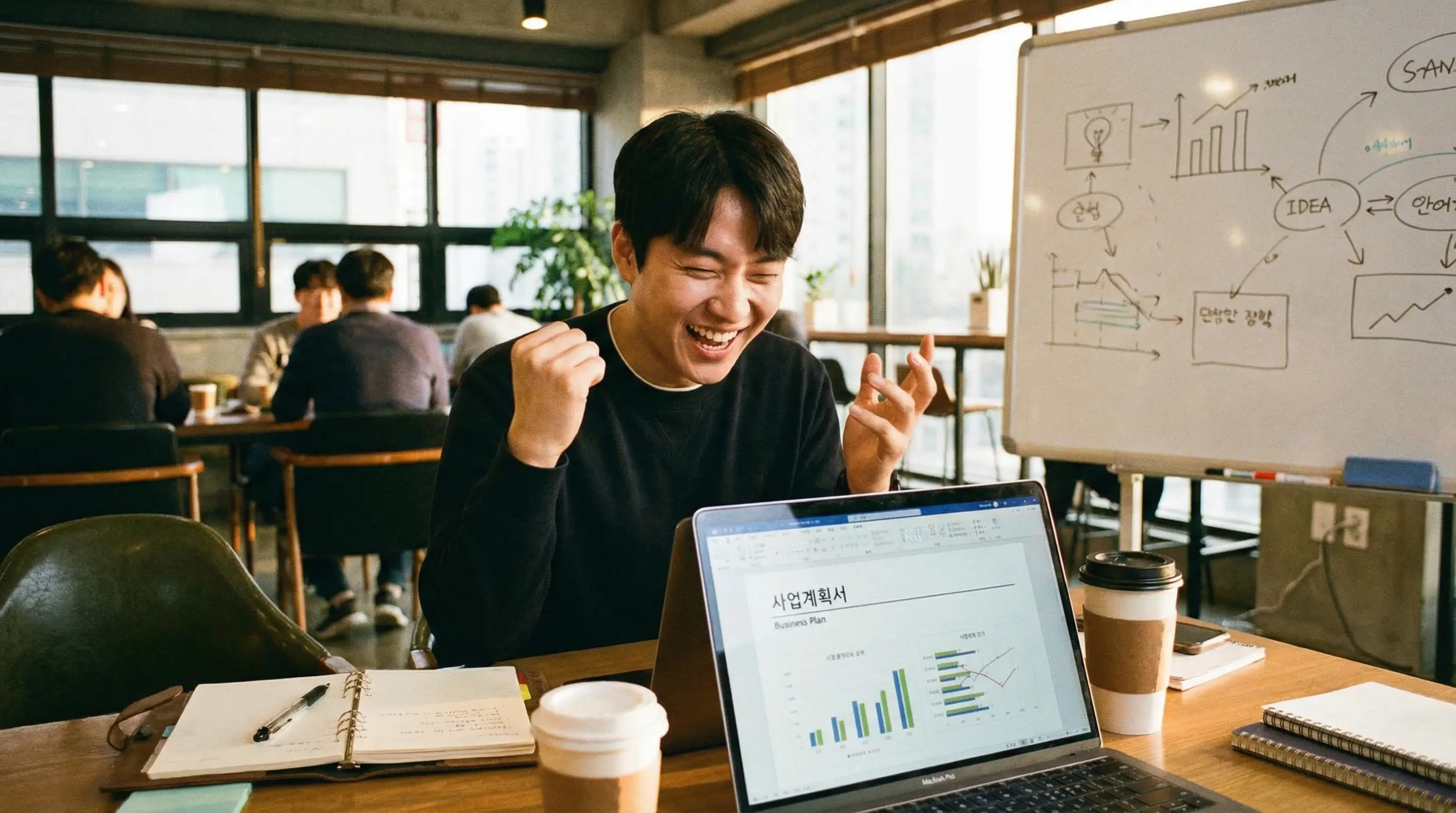노트북 앞에서 번뜩이는 아이디어를 사업계획서로 작성하며 기뻐하는 예비 창업자의 모습