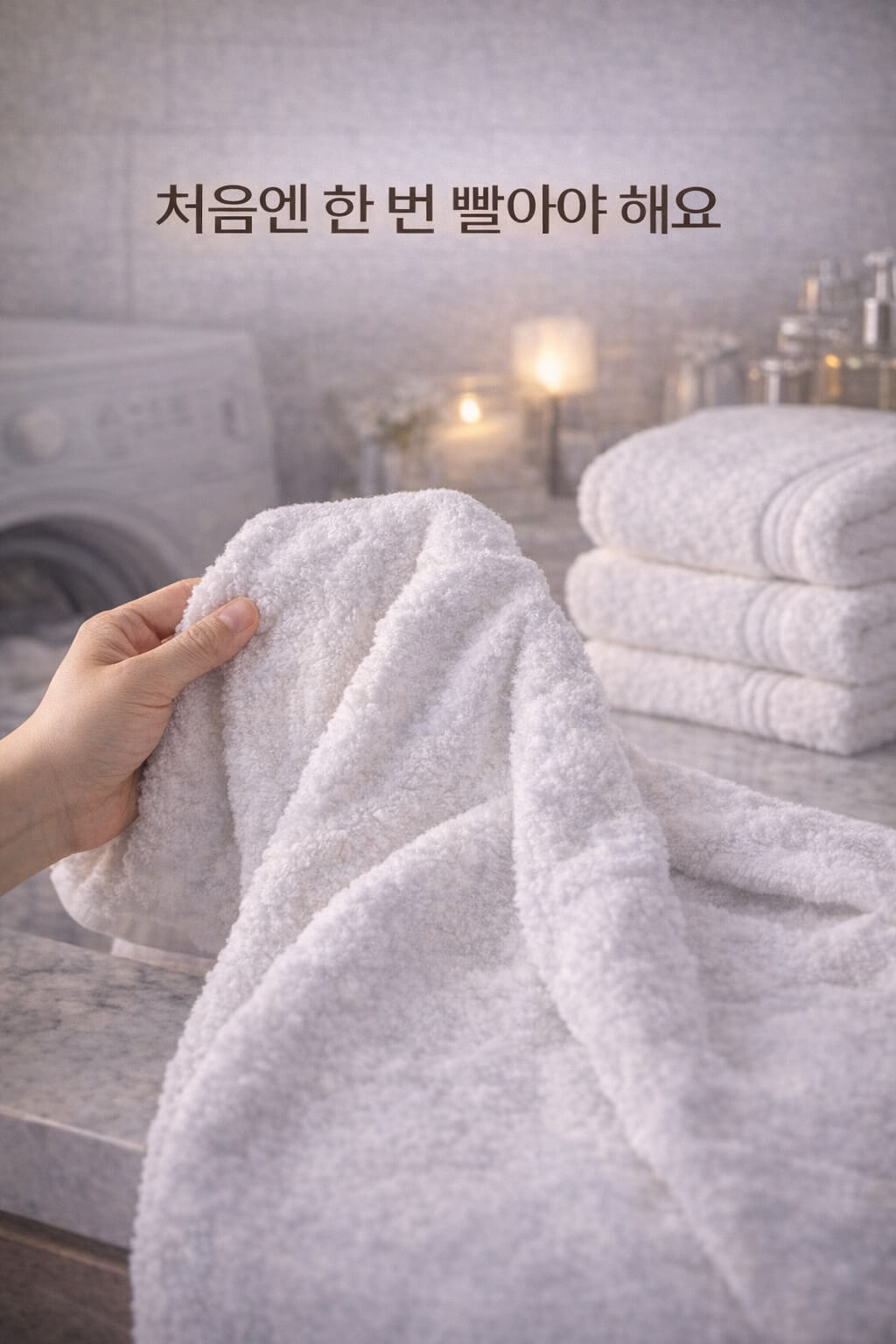 새 수건은 처음 한 번 빨아야 해요 문구와 함께 손으로 수건을 펼쳐보는 이미지