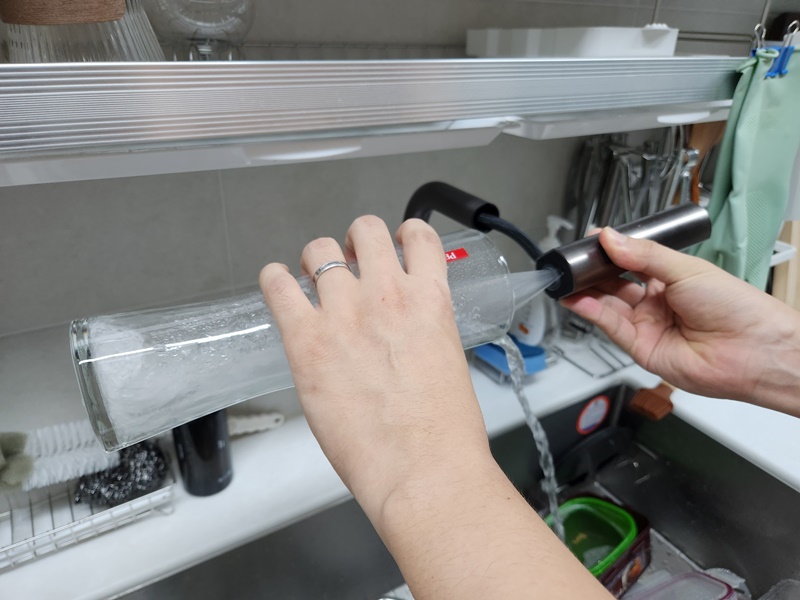 고수압모드 활용하여 긴 컵을 세척하는 모습