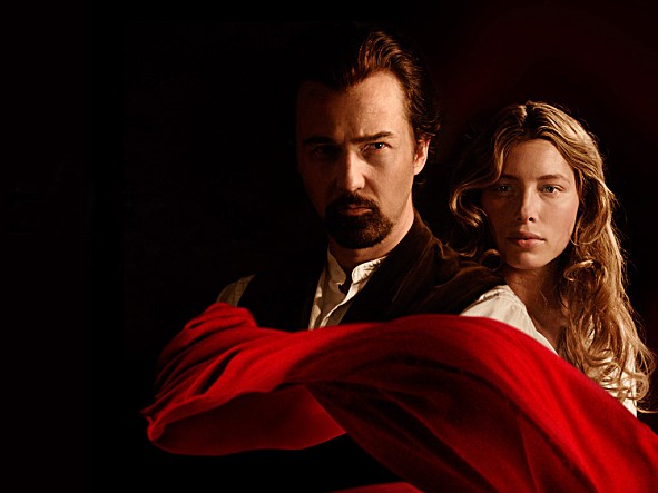 영화 '일루셔니스트'의 에드워드 노튼과 제시카 비엘이 어두운 배경에 붉은 천을 휘감은 채 신비로운 분위기를 연출하는 포스터 이미지