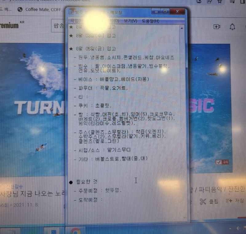 윈도우 메모장을 활용해 카페 재료 입고 일정을 관리하는 화면. 원두, 소시지, 빙수 재료, 베이스, 파우더, 쿠키, 빵류 등 카테고리별로 상세하게 기록된 발주 데이터와 도착 예정 품목 메모.