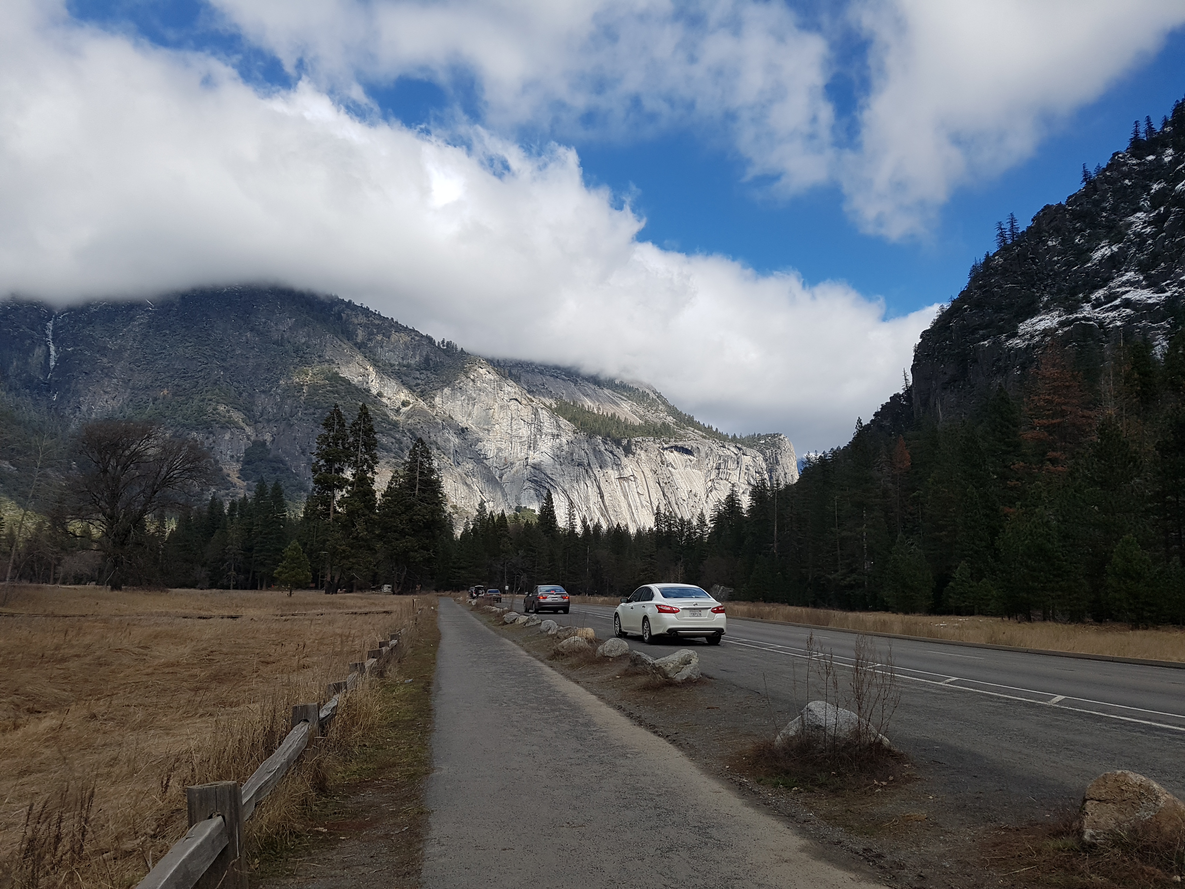 요세미티 밸리 도로를 달리는 자동차들과 주변의 화강암 산맥 전경