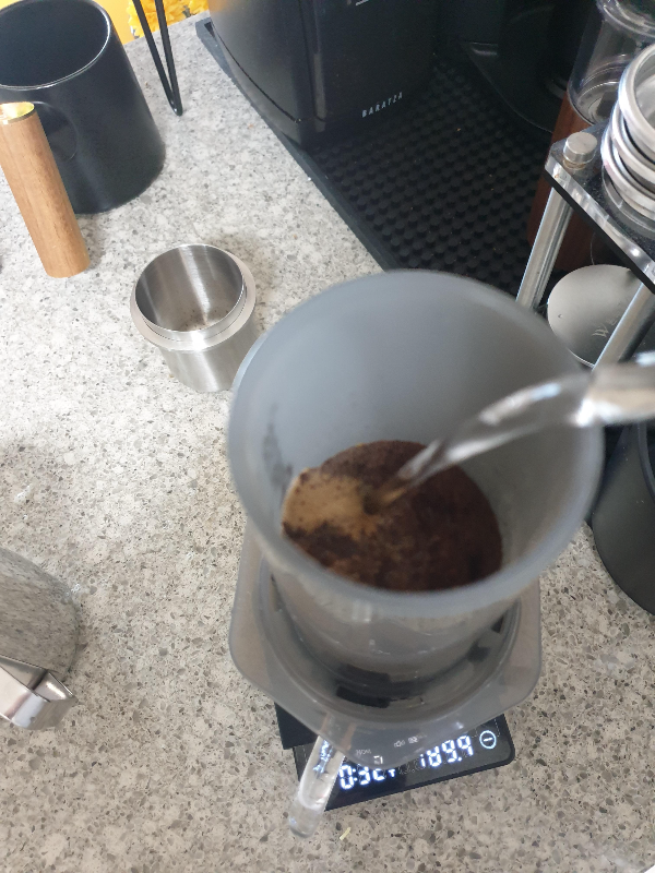 저울 위에 올린 에어로프레스에 물을 붓는 모습. 저울은189.9ml 를 가르키고 있다.