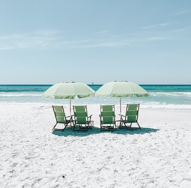 해변에-비치우산과-녹색의-의자