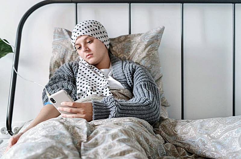 병실에-누워-핸드폰을-만지는-환자-모습