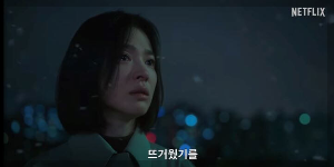 한 여성이 벼랑 끝에 서있다. 자막 "뜨거웠기를"