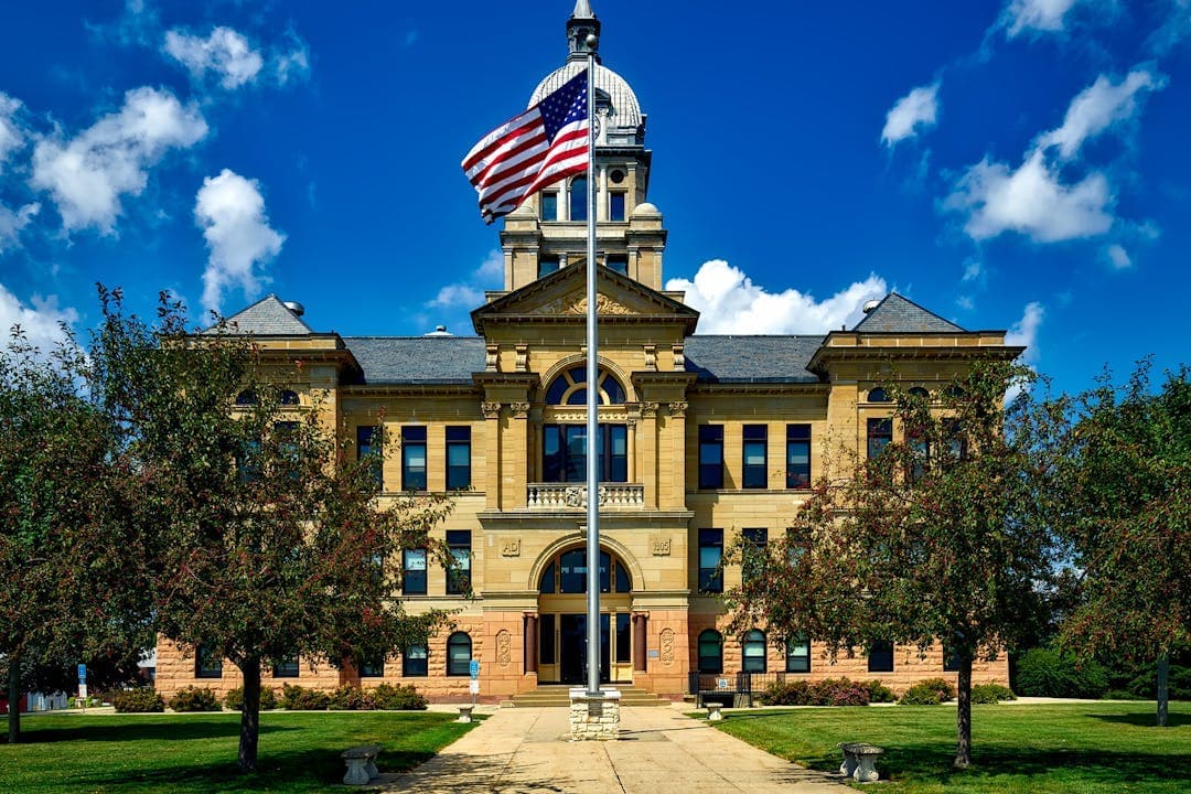 청사 앞에 미국 국기가 게양된 고전 양식의 법원 건물 외관