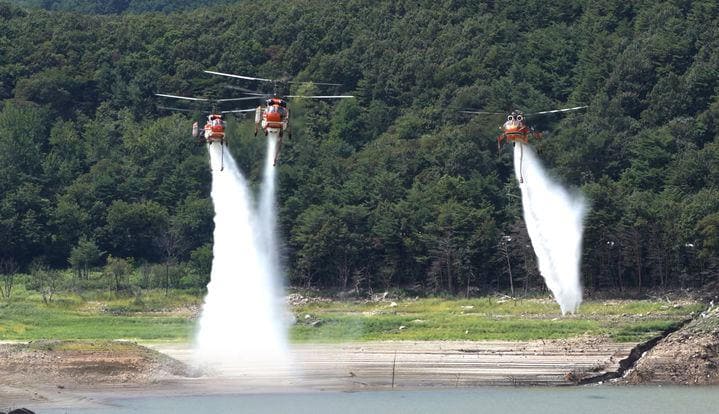 A Forest Service helicopter is dropping water into the Obong Reservoir in Gangneung.
