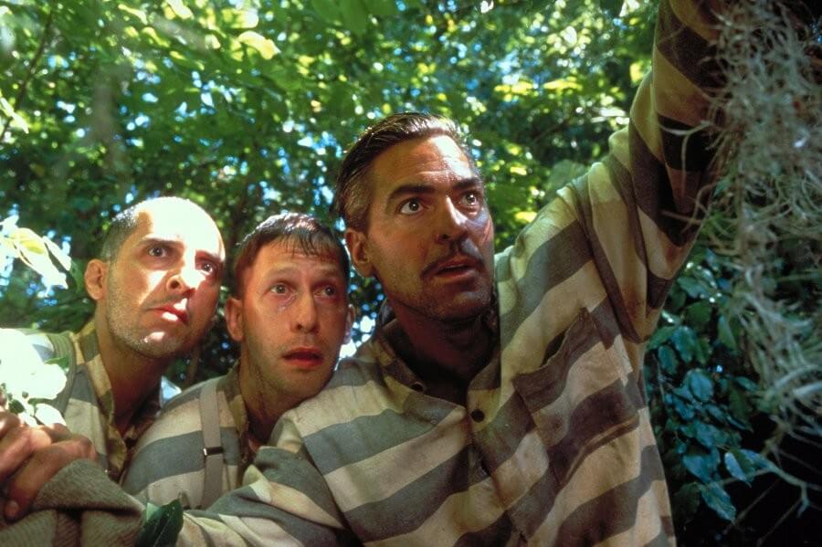 죄수옷을 입은 세 남자가 어딘가를 응시하고 있는 모습