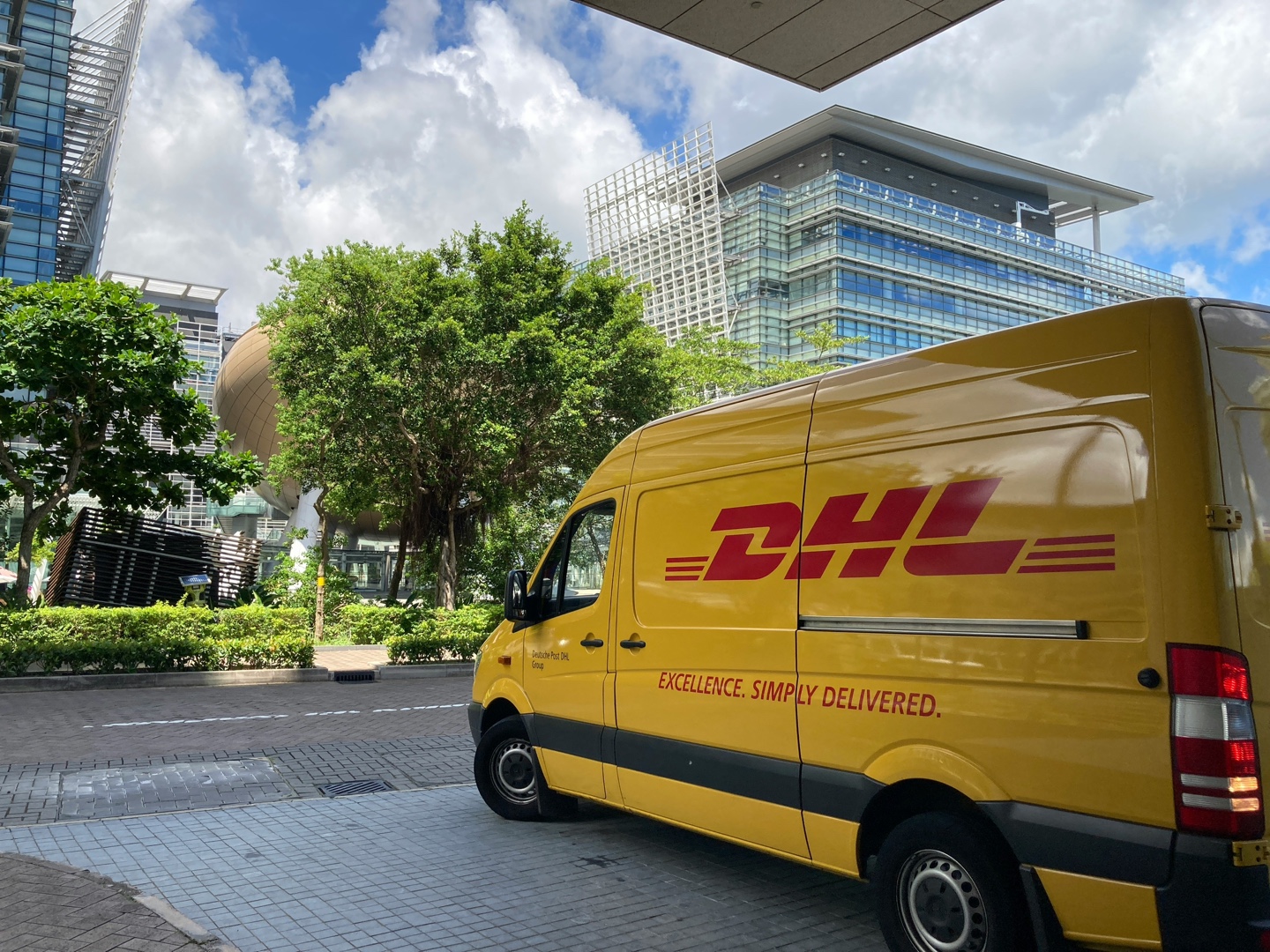 배송하기 위해 이동하는 DHL 차 사진