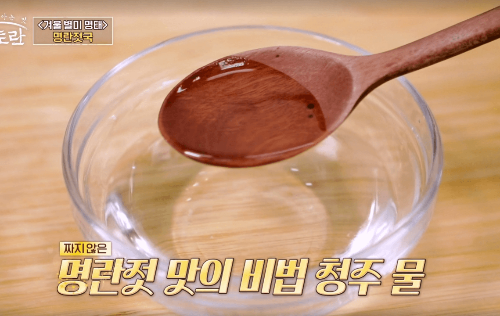 투명그릇에-청주물이-담겨있고-나무숟가락으로-뜨고있다