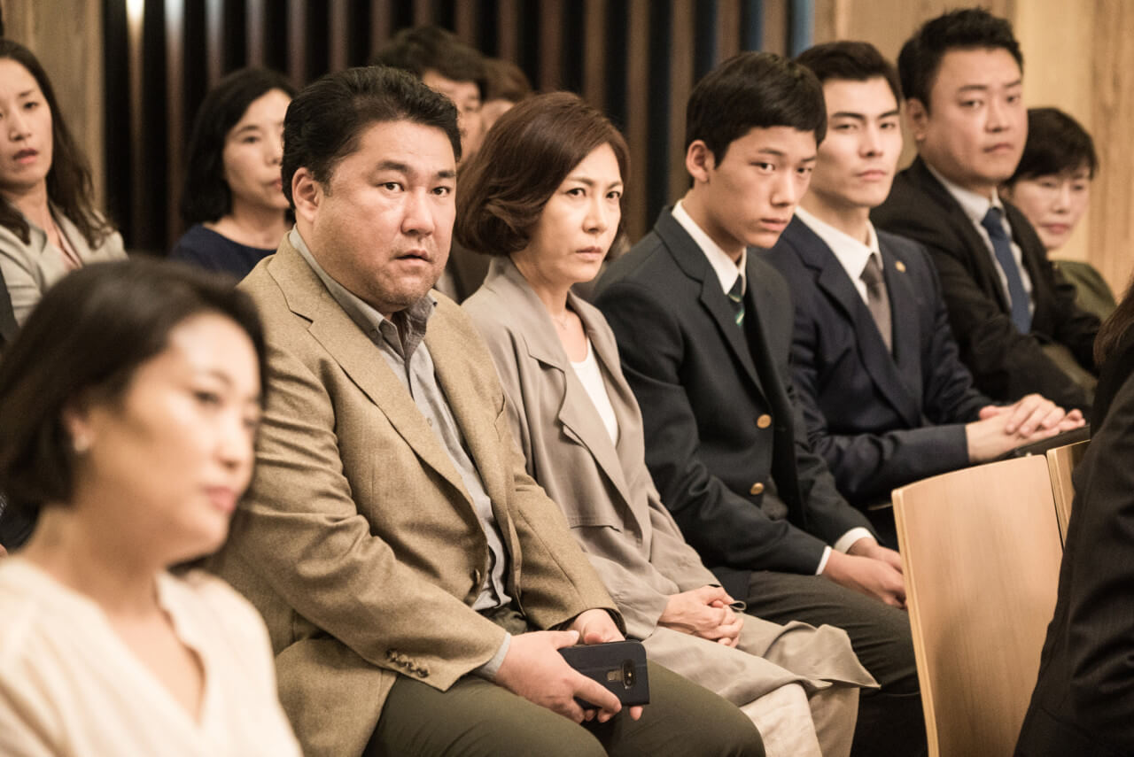 법정에 앉아있는 학부모와 학생