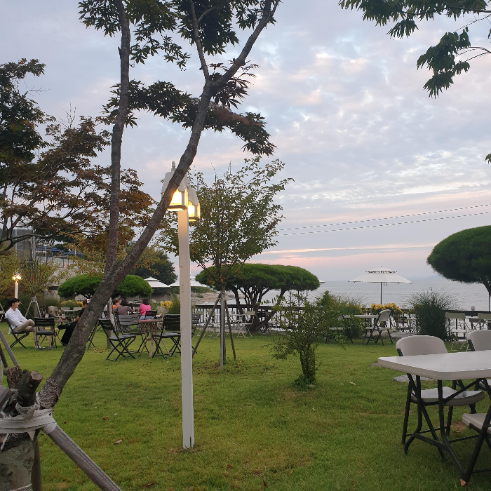 토크라피 : 강화도 동막해변 오션뷰 카페_석양이 살짝 비치는 야외 정원