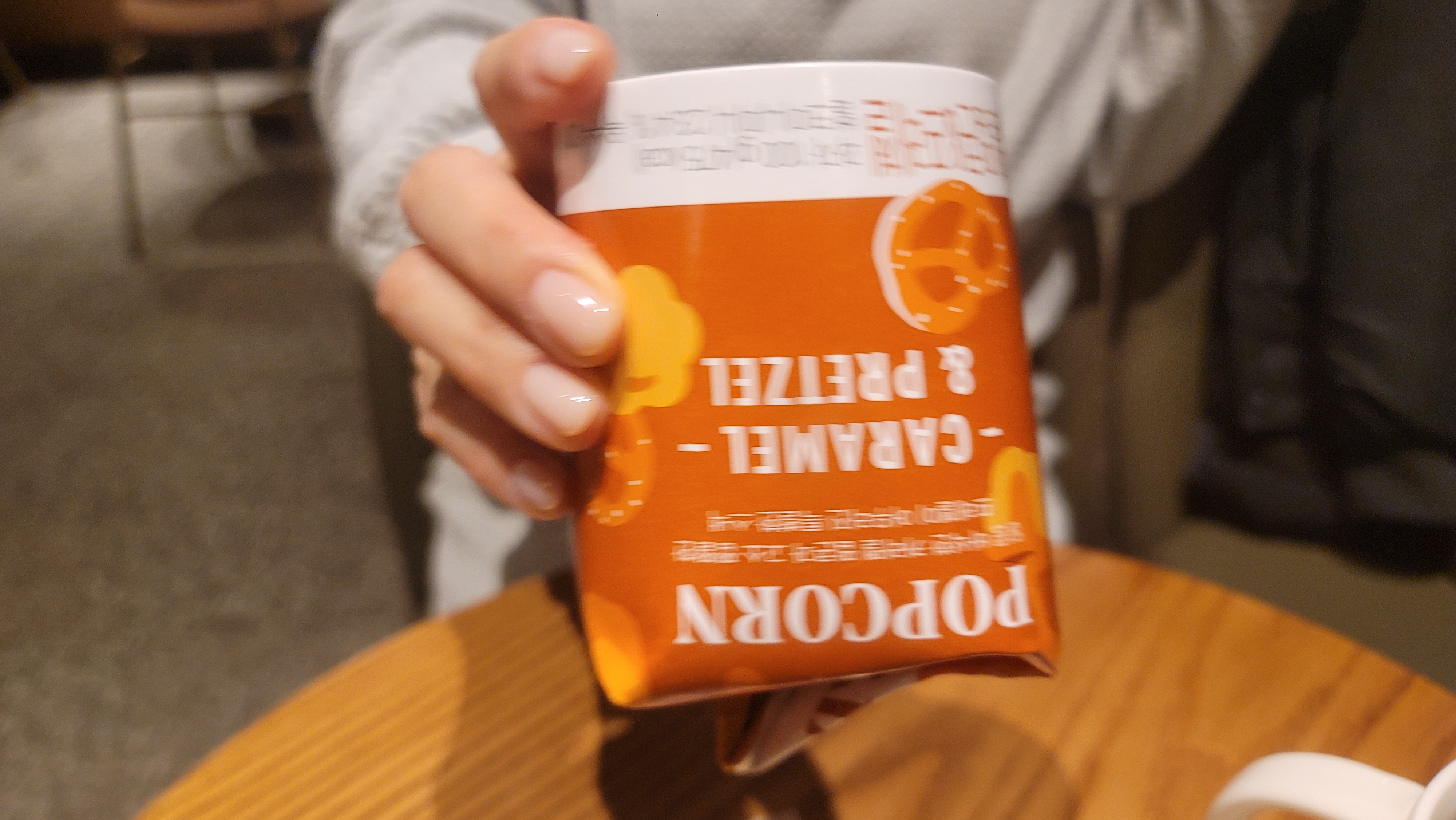 먹다 남은 스타벅스 캐러멜 팝콘, 포장 케이스를 접어서 거꾸로 뒤집어 흔드는 모습