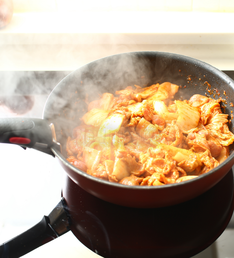 강불에 볶아지는 김치찌개 재료들, Stir-frying Kimchi and pork on high heat for deep flavor