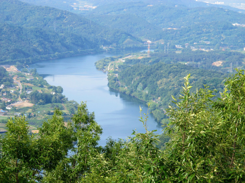 가운데 강줄기 양쪽으로 펼쳐진 숲과 산책길 모습