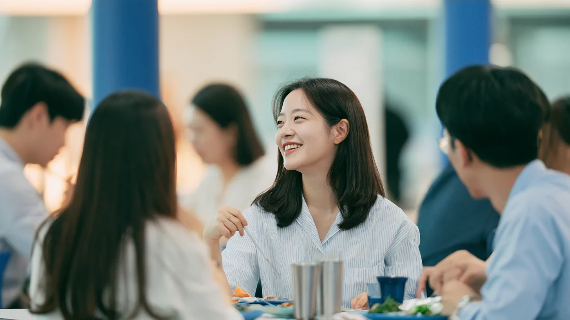 회사 구내식당에서 동료들과 점심을 먹는 신입 사원
