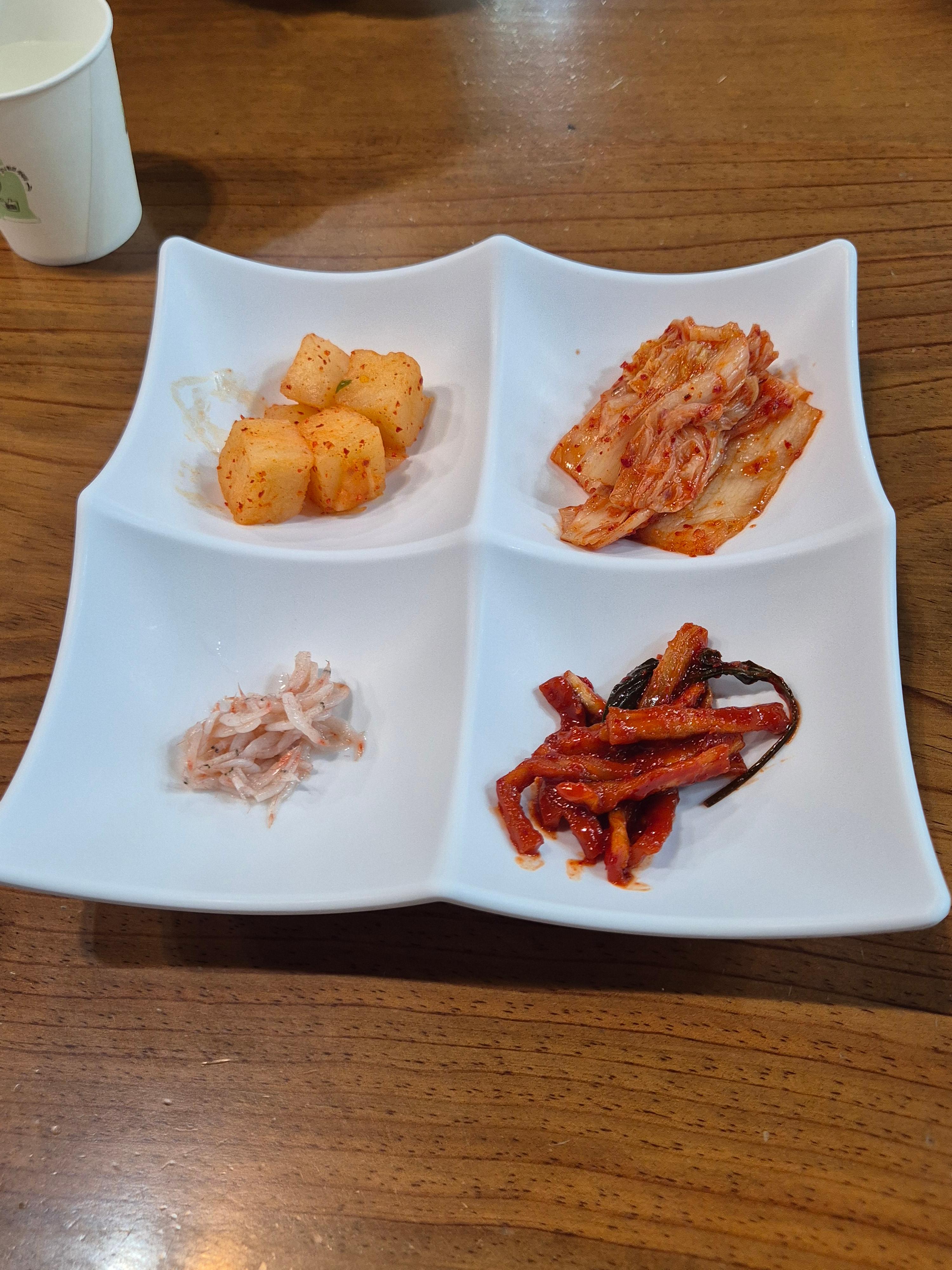 김치와 깍두기, 장아찌, 새우젓이 담긴 콩나물국밥 밑반찬