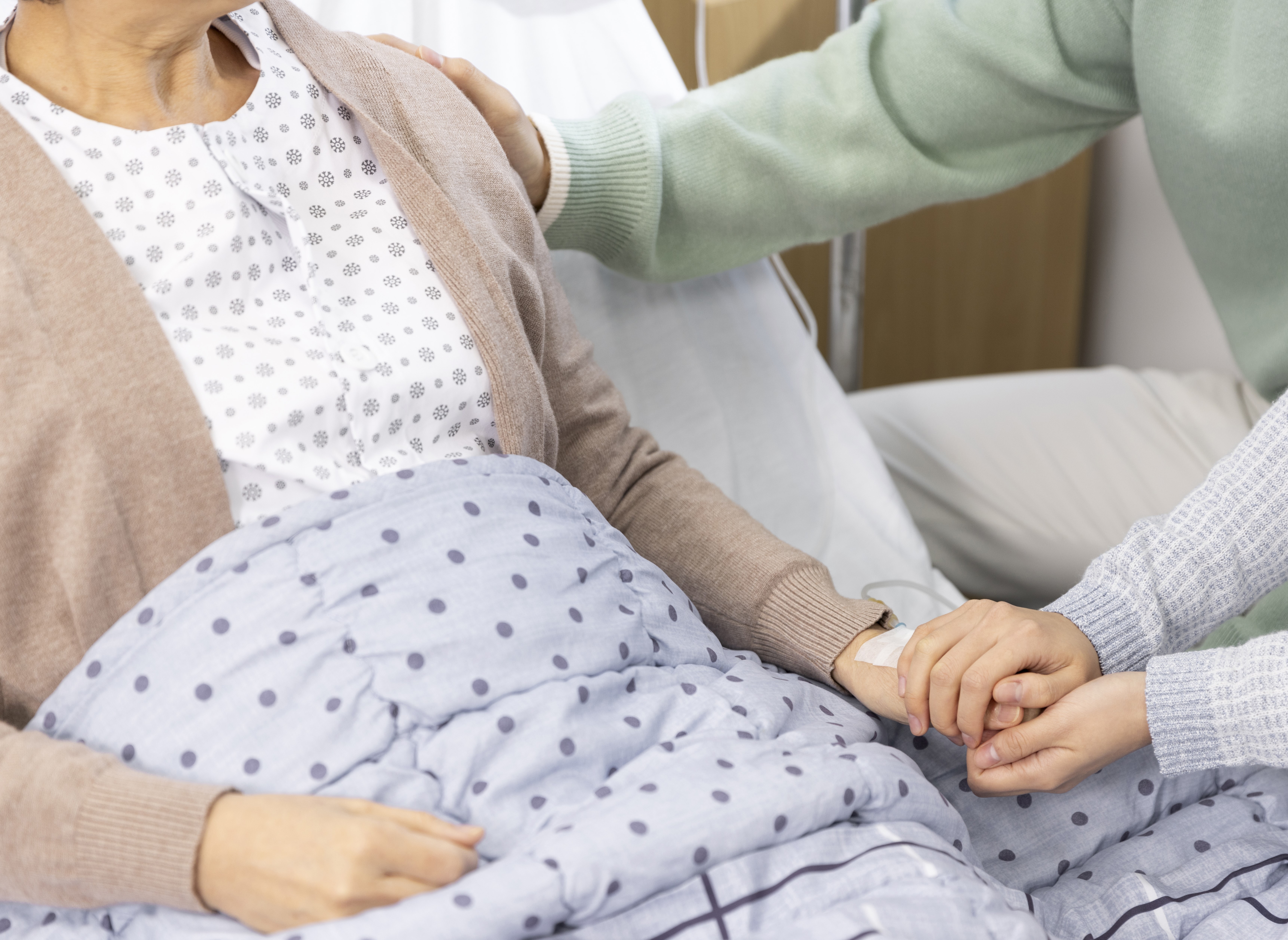 입원 중인 환자와 보호자가 함께 있는 병원 장면, 갑작스러운 의료비 상황을 상징