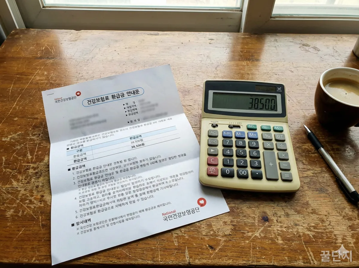 건강보험 환급금 통지서와 계산기가 놓인 책상