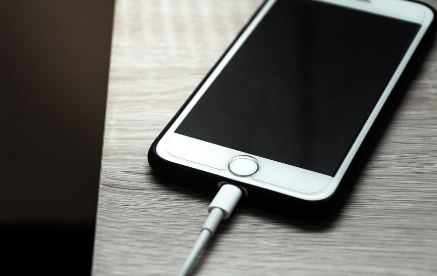 책상 위에 충전중인 핸드폰이 놓여있는 장면