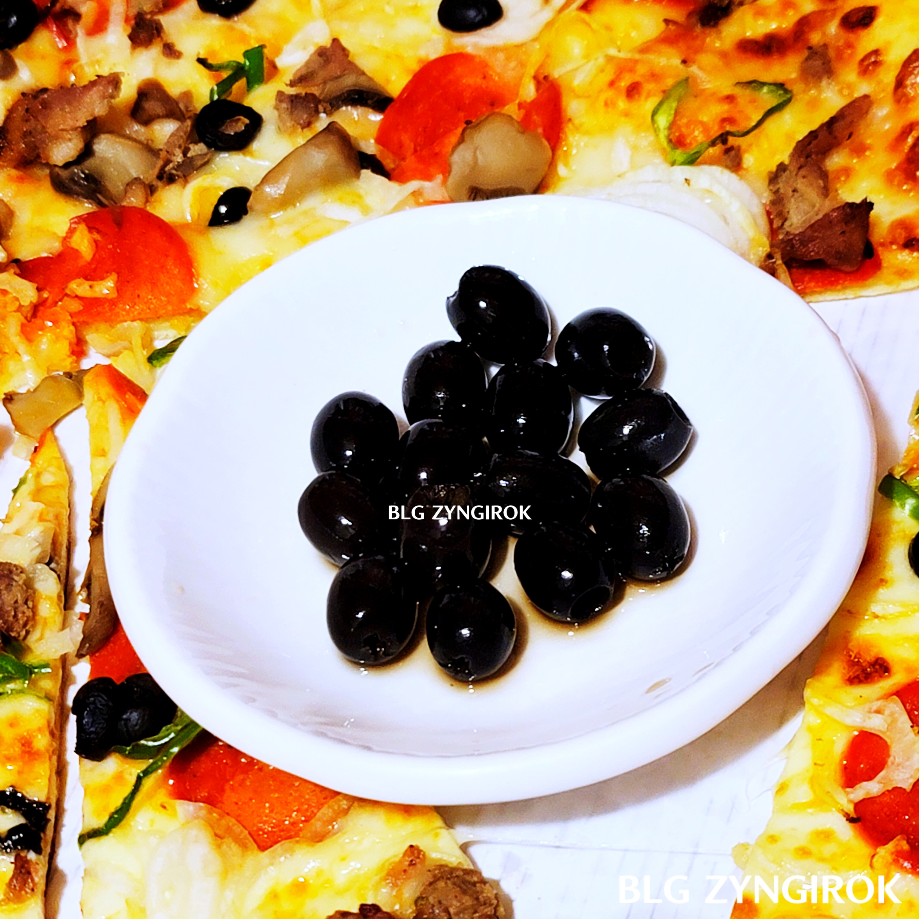 접시에-담은-올리브가-피자와-함께-있다.