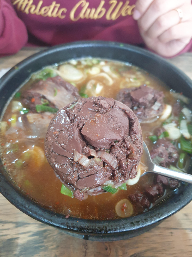 다진 양념을 푼 순대 국밥. 순대 하나를 숟가락에 올려 놨다.